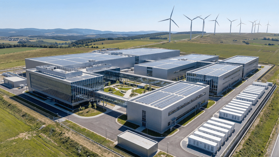 Luftaufnahme eines modernen, nachhaltigen Industriekomplexes mit Solaranlagen auf den Dächern und Batteriespeichern